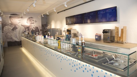 Digital signage screens behind the counter of a shop